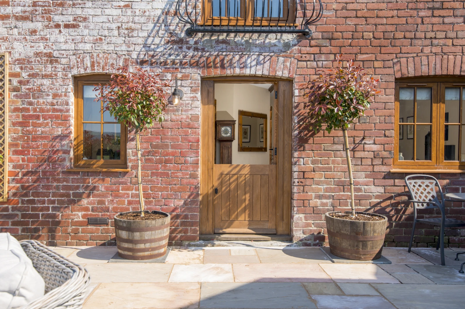 Sunlit patio and exterior view of Gablebach surrounded by the Welsh countryside