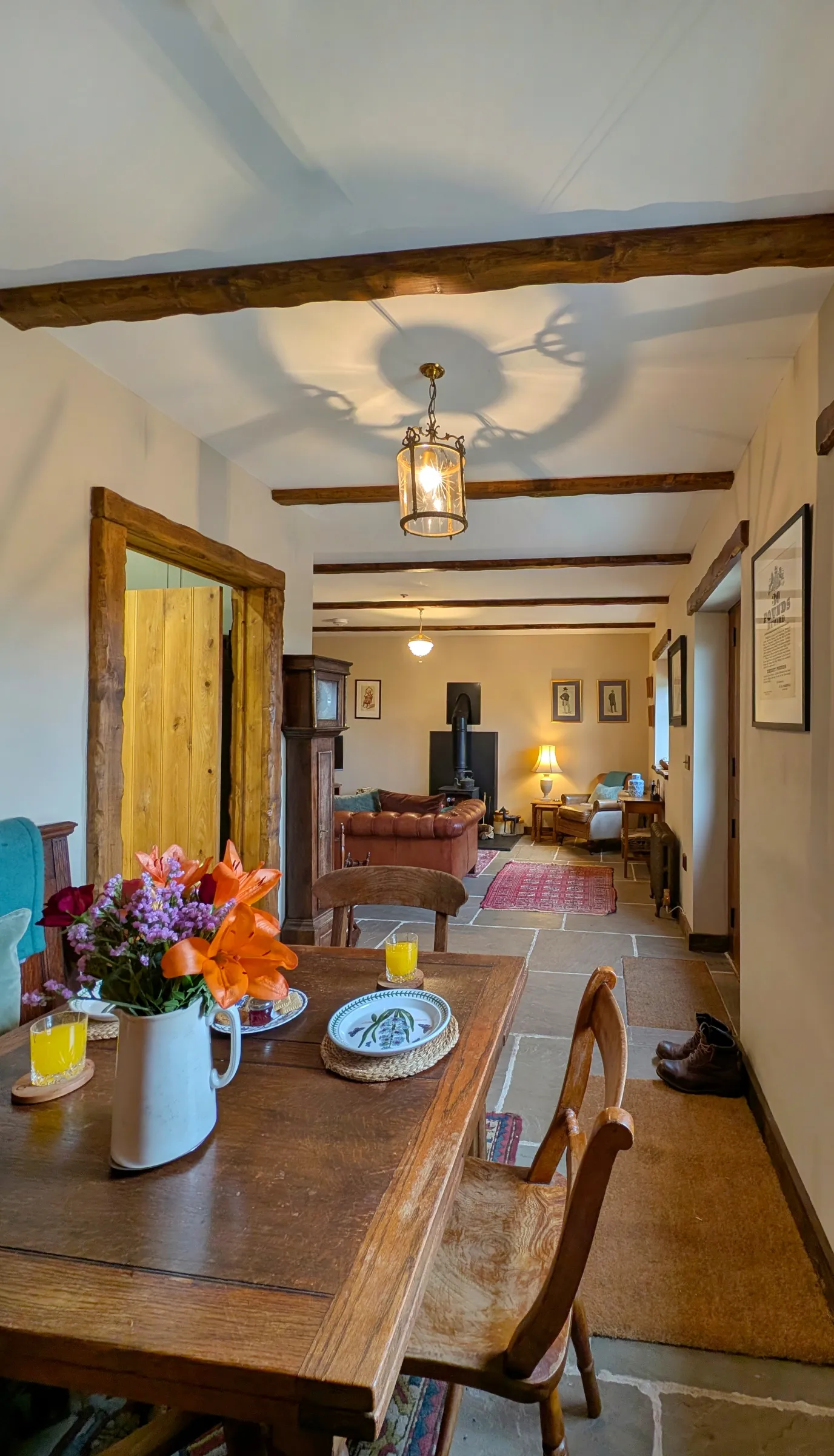 Dining table, living room and wood burning stove inside Gablebach cottage in rural Wales