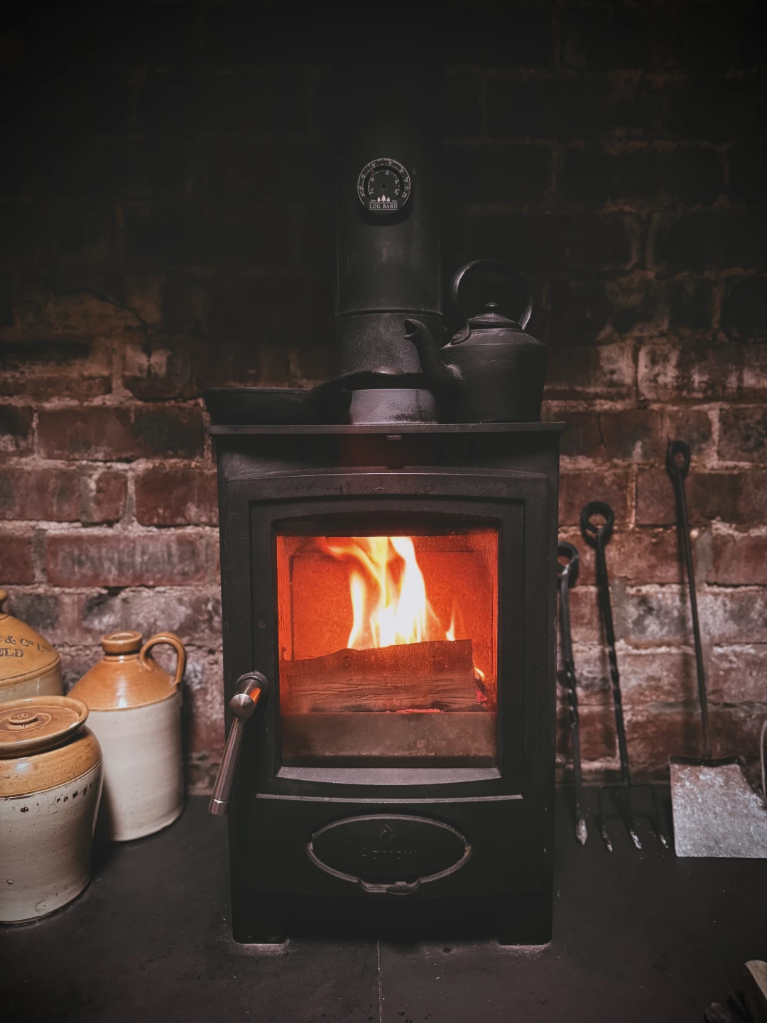 Wood burner glowing inside The Old Laundry Room cabin at Black Mountain Escapes.