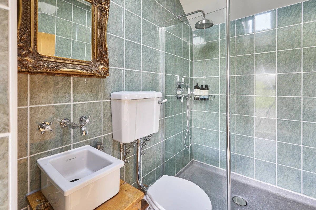 Private external shower room at Y Golchdy with rainfall shower, traditional fittings and countryside cabin styling.